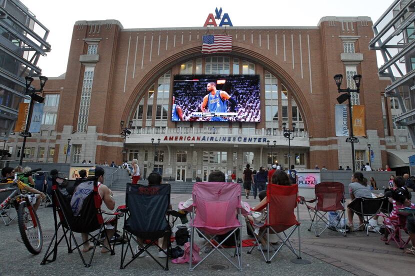 Fans watch the game from Victory Plaza outside the arena at the American Airlines Center in...
