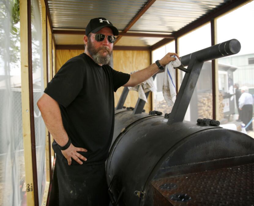 Pitmaster John Mueller poses for a photo with his smoker at John Mueller Meat Co.