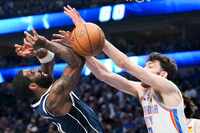 Dallas Mavericks guard Kyrie Irving (11) is fouled by Oklahoma City Thunder forward Chet...