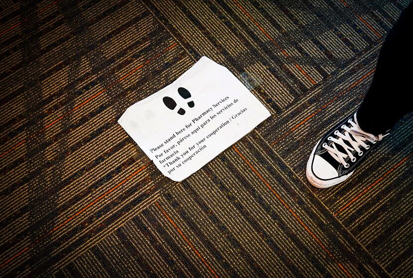 A sign on the floor instructed clients where to wait outside the doorway to fill...