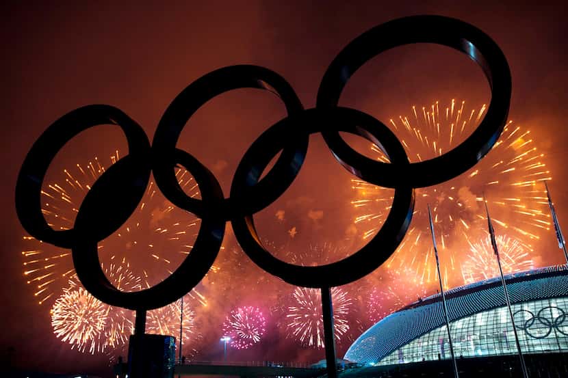 The Olympic Rings are silhouetted as fireworks light up the sky during the closing...