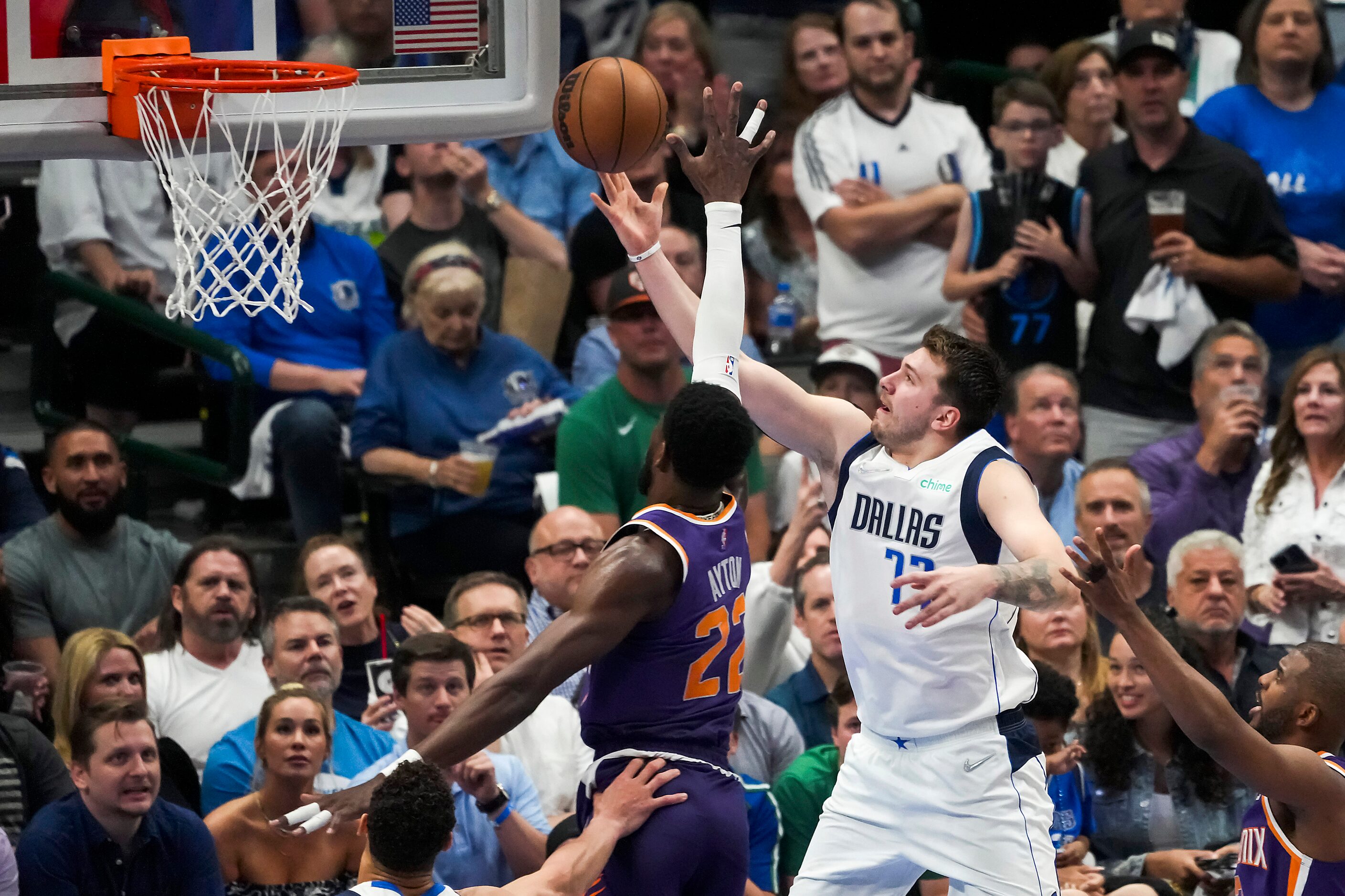 Dallas Mavericks guard Luka Doncic (77) scores past Phoenix Suns center Deandre Ayton (22)...