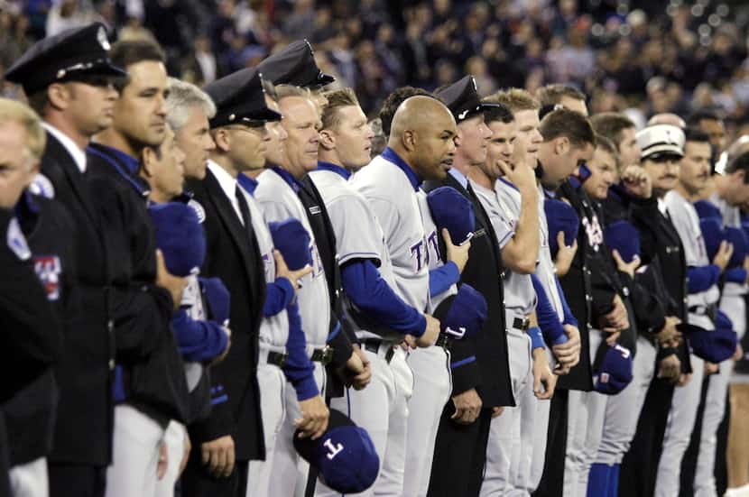 Members of the Texas Rangers stand interspersed with firefighters, EMTs and police from the...