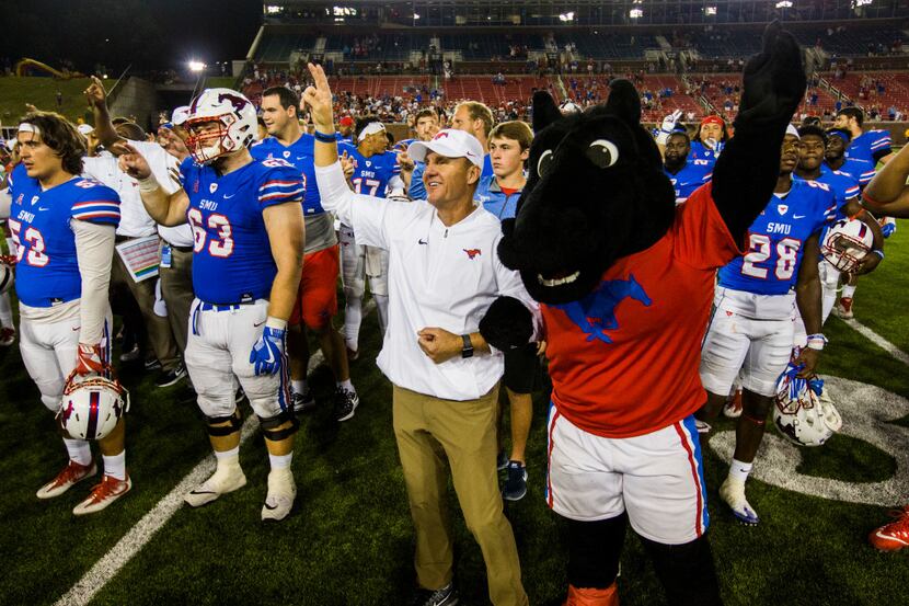 Southern Methodist Mustangs head coach Chad Morris sings the school song with his team after...