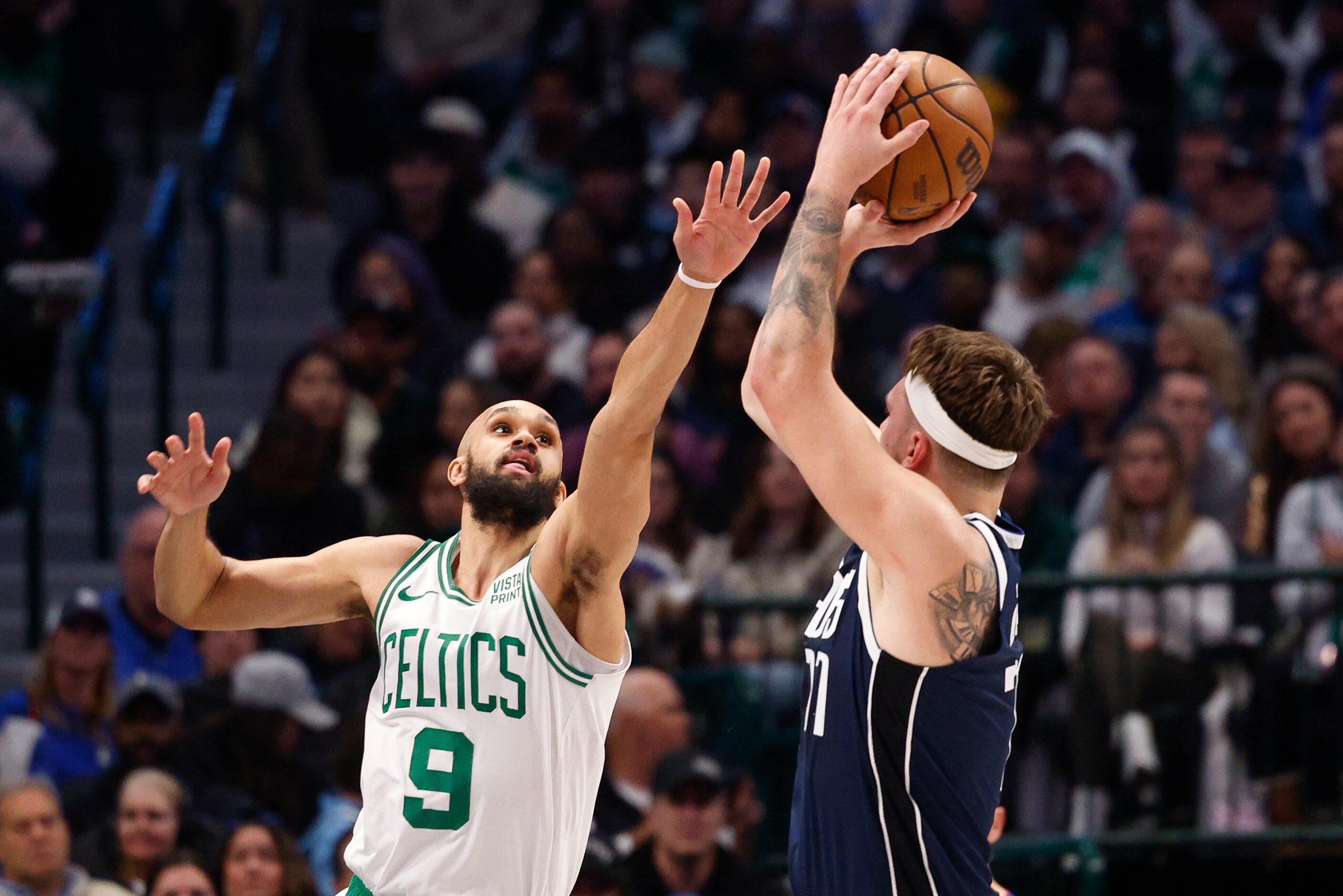 Dallas Mavericks guard Luka Doncic (77) shoots over Boston Celtics guard Derrick White (9)...