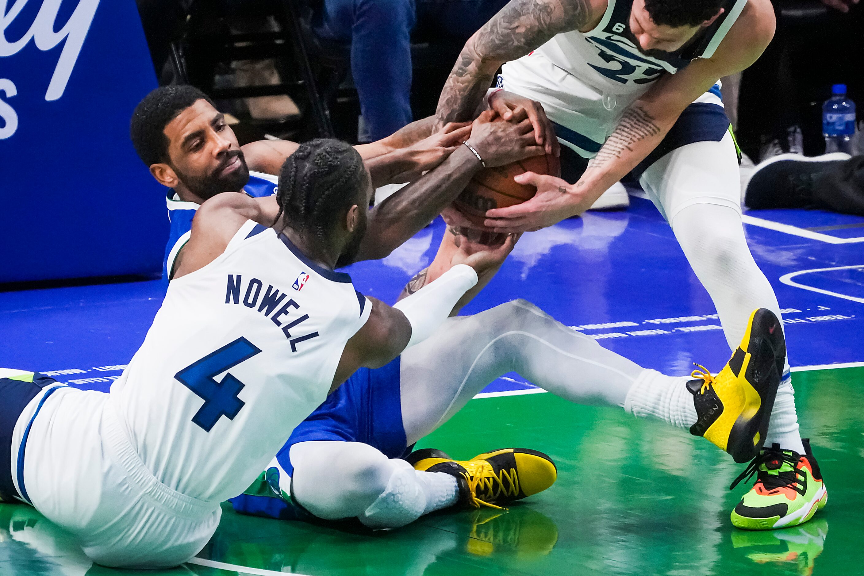 Dallas Mavericks guard Kyrie Irving (2) wrestles for a loose ball against Minnesota...