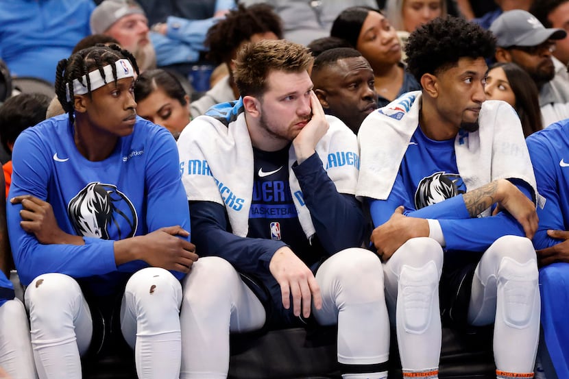 Dallas Mavericks guard Luka Doncic (center) watches the fourth quarter from the bench as the...