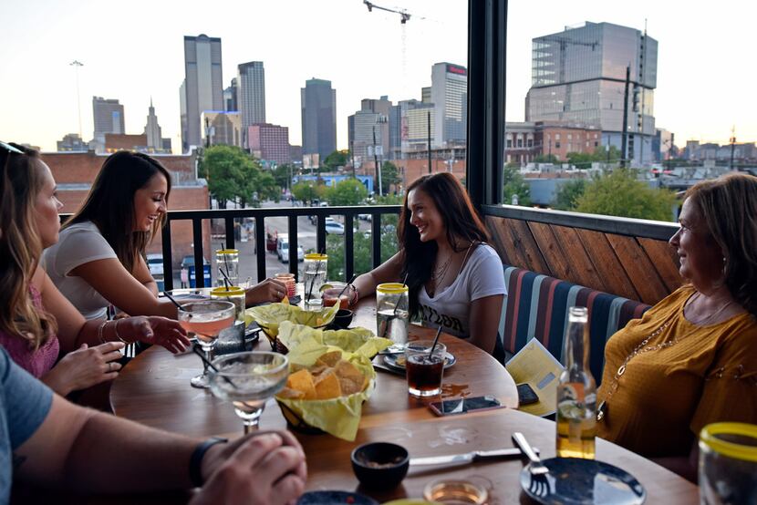 Kayla Prachyl, far-left, and Taylor Maliska, right, have dinner with family on the rooftop...