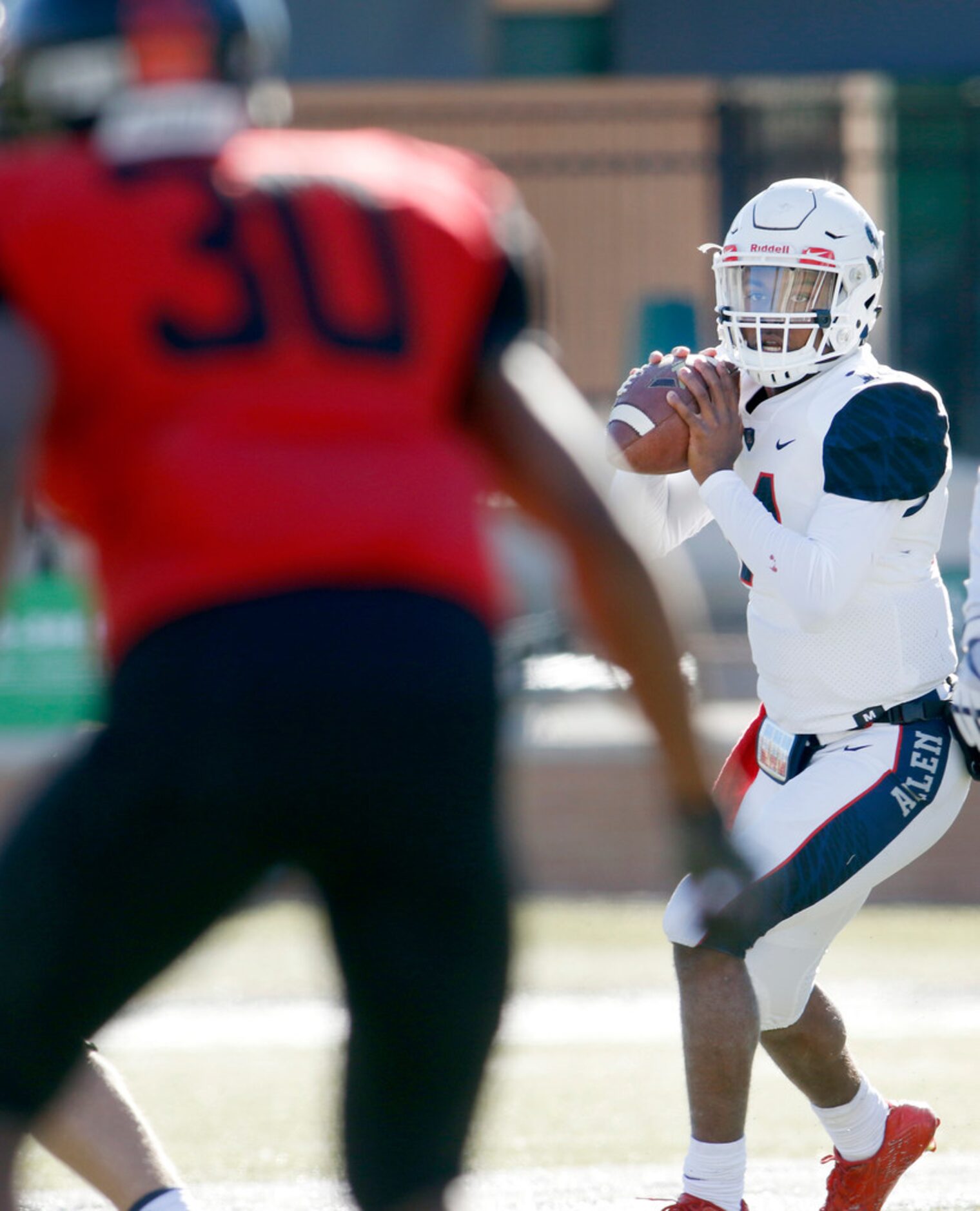 Allen quarterback Grant Tisdale (14) sits in the pocket in search of a receiver during first...