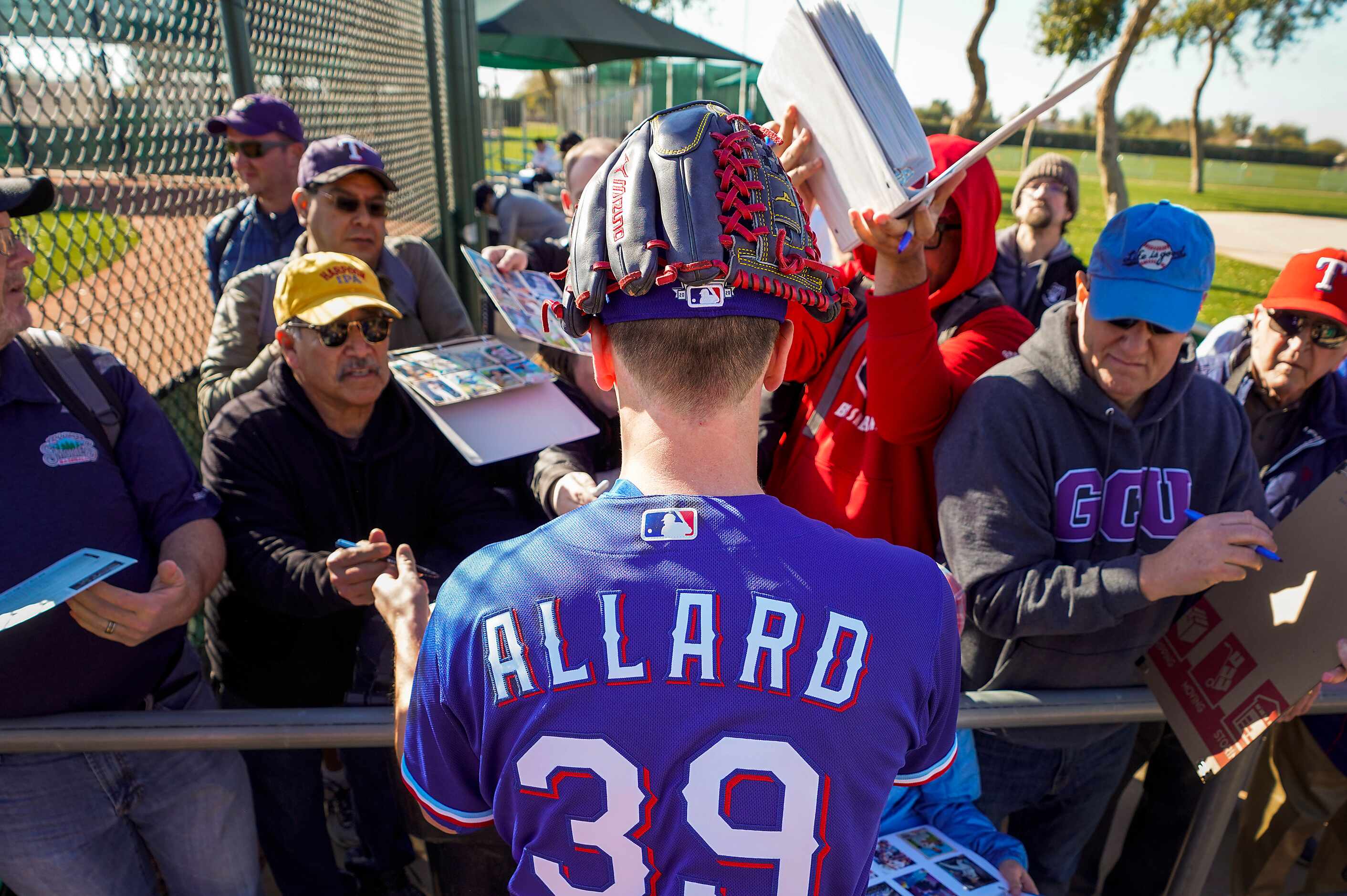 Texas Rangers pitcher Kolby Allard signs autographs for fans before the first spring...