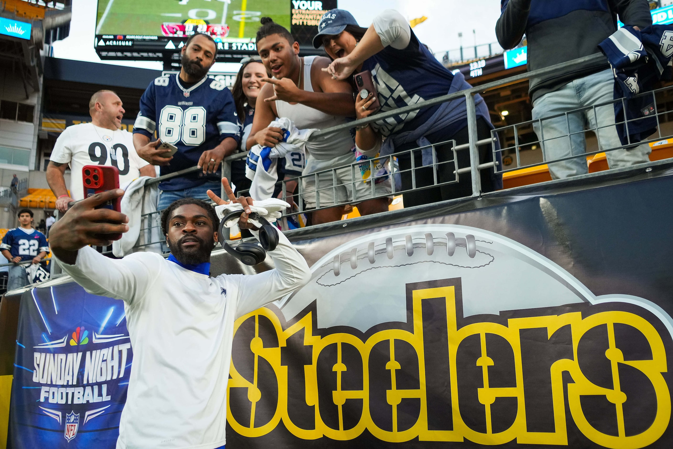 Dallas Cowboys cornerback Trevon Diggs takes a selfie with fans before an NFL football game...