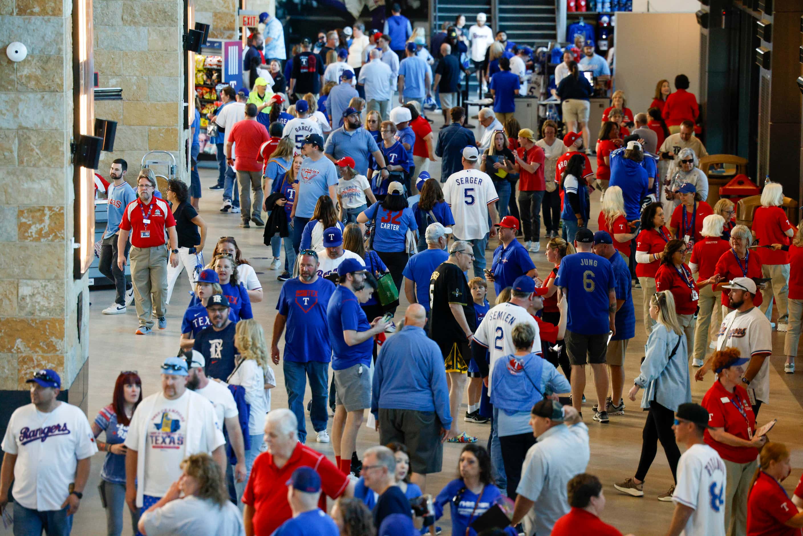 Dozens of Texas Rangers fans walk around the concourse before the season opener at Globe...
