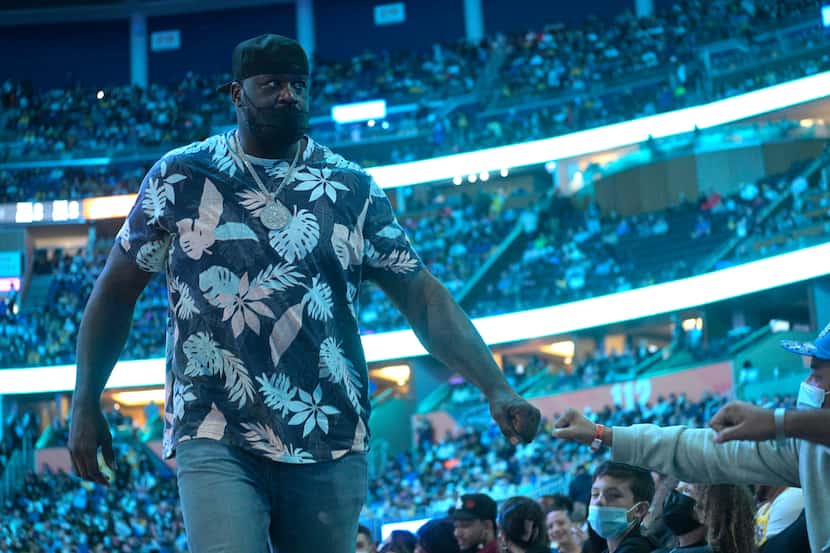 Shaquille O'Neal fist bumps fans while leaving his court side seat during the second half of...