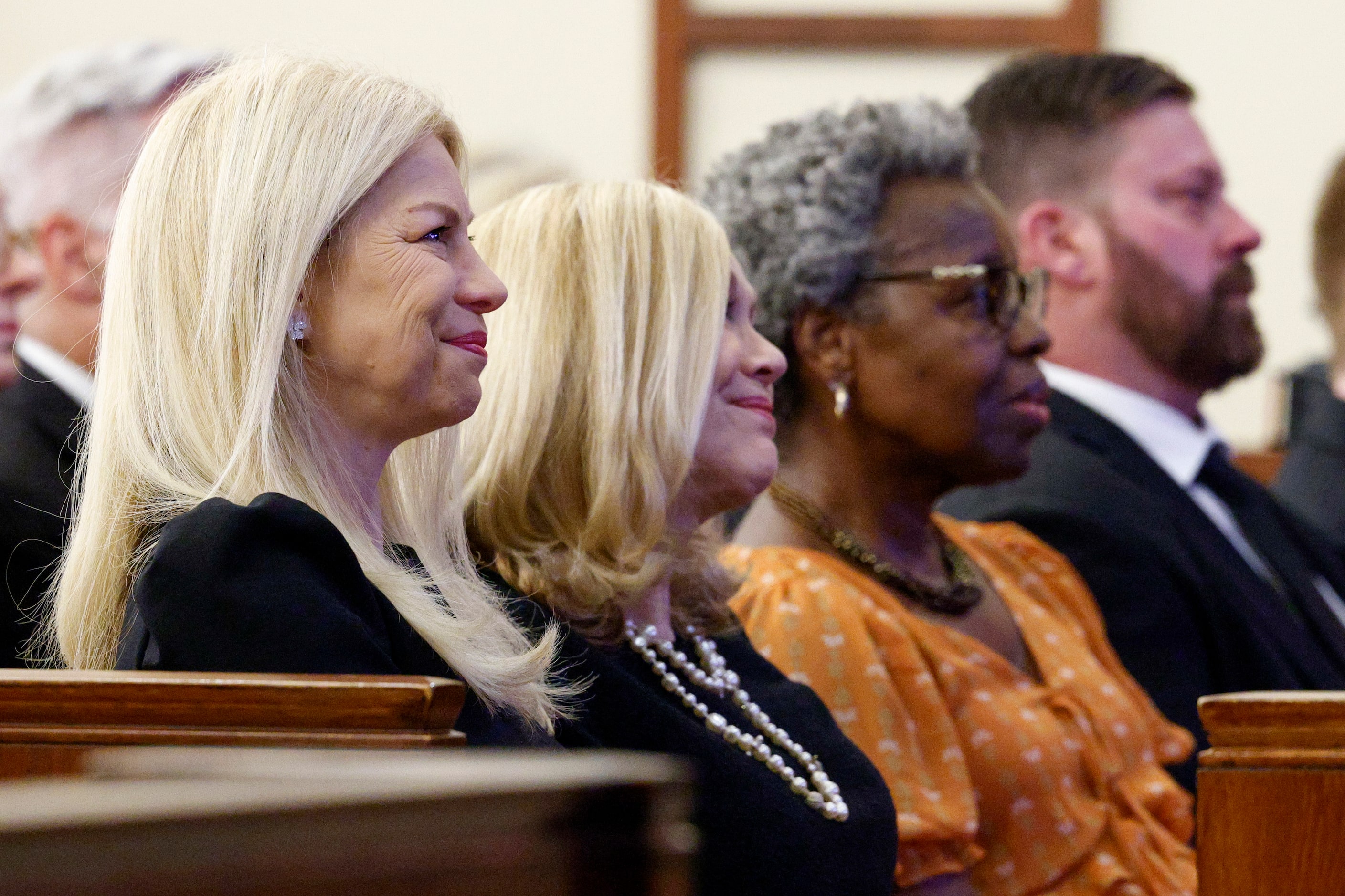 Sarah Dodd (left) smiles as she listens to a eulogy alongside her mother Vicki Dodd during a...