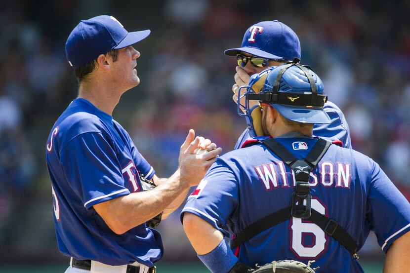 Texas Rangers starting pitcher Cole Hamels gets a visit from catcher Bobby Wilson  and...