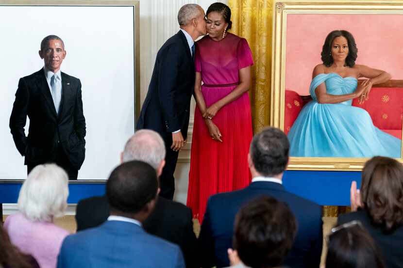 Former President Barack Obama kisses his wife former first lady Michelle Obama after they...