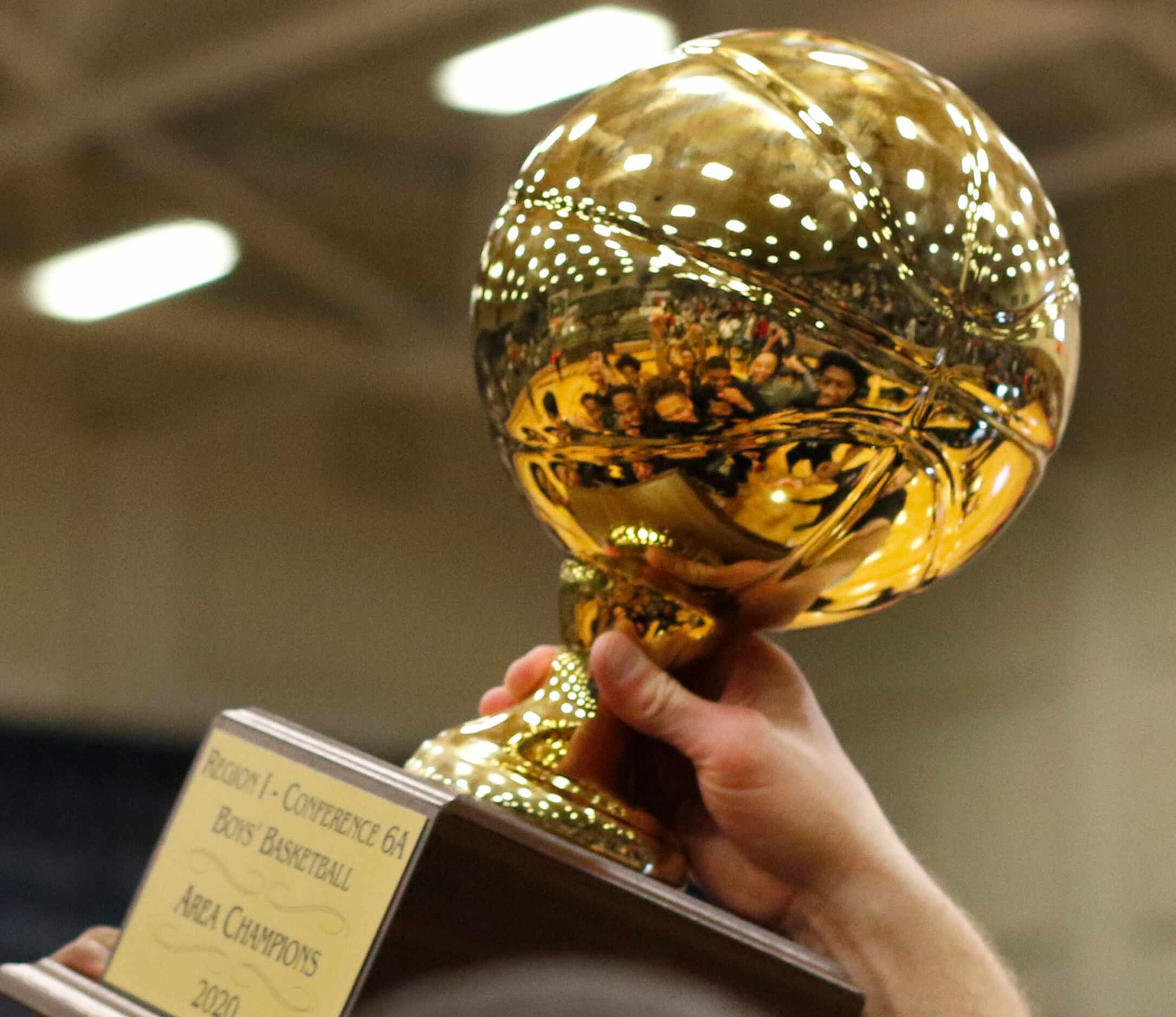 Members of the Waxahachie Indians are reflected in the 6A Region 1 Area Champions trophy as...