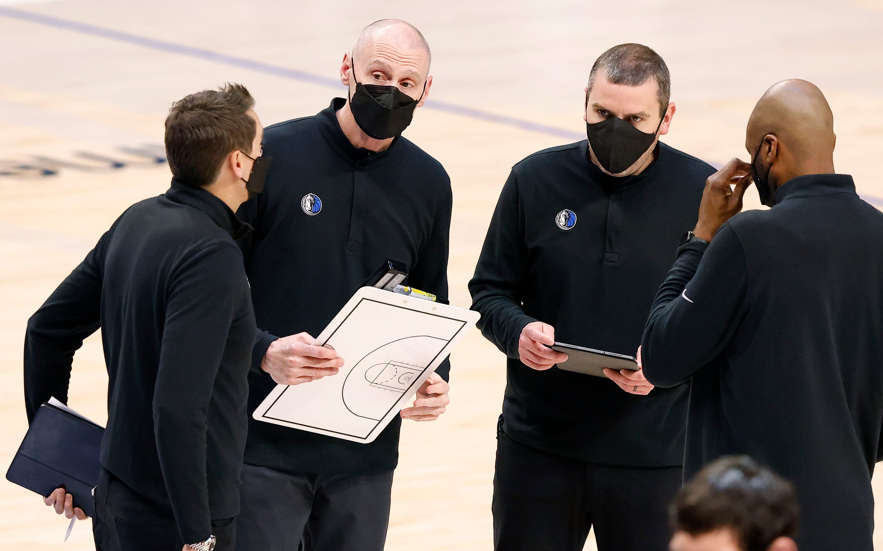 Dallas Mavericks head coach Rick Carlisle (second from left) gathers his assistants together...