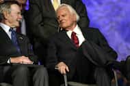 Former President George Bush and Billy Graham visit on the stage at the Billy Graham Crusade...