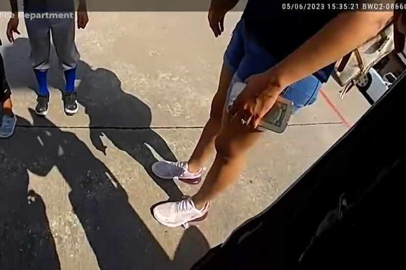 A screengrab from a video released by Allen police shows an officer talking to two children...
