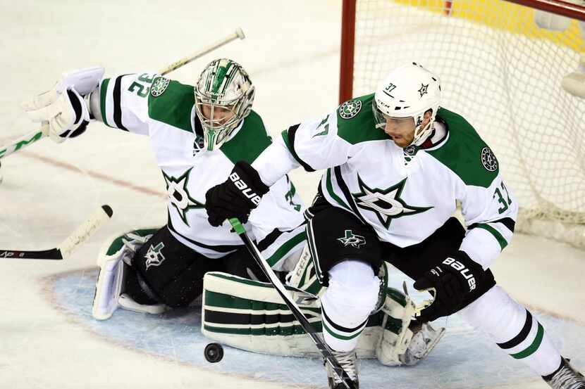 Mar 25, 2015; Calgary, Alberta, CAN; Dallas Stars goalie Kari Lehtonen (32) and defenseman...