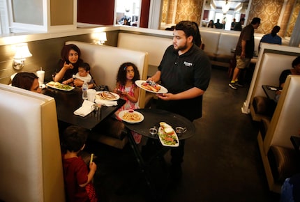 Joseph Rivera delivers food to patrons at Ellen's in May 2018. 