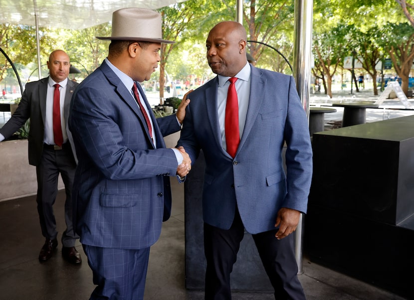 GOP presidential candidate and South Carolina Sen. Tim Scott (right) shakes hands with...