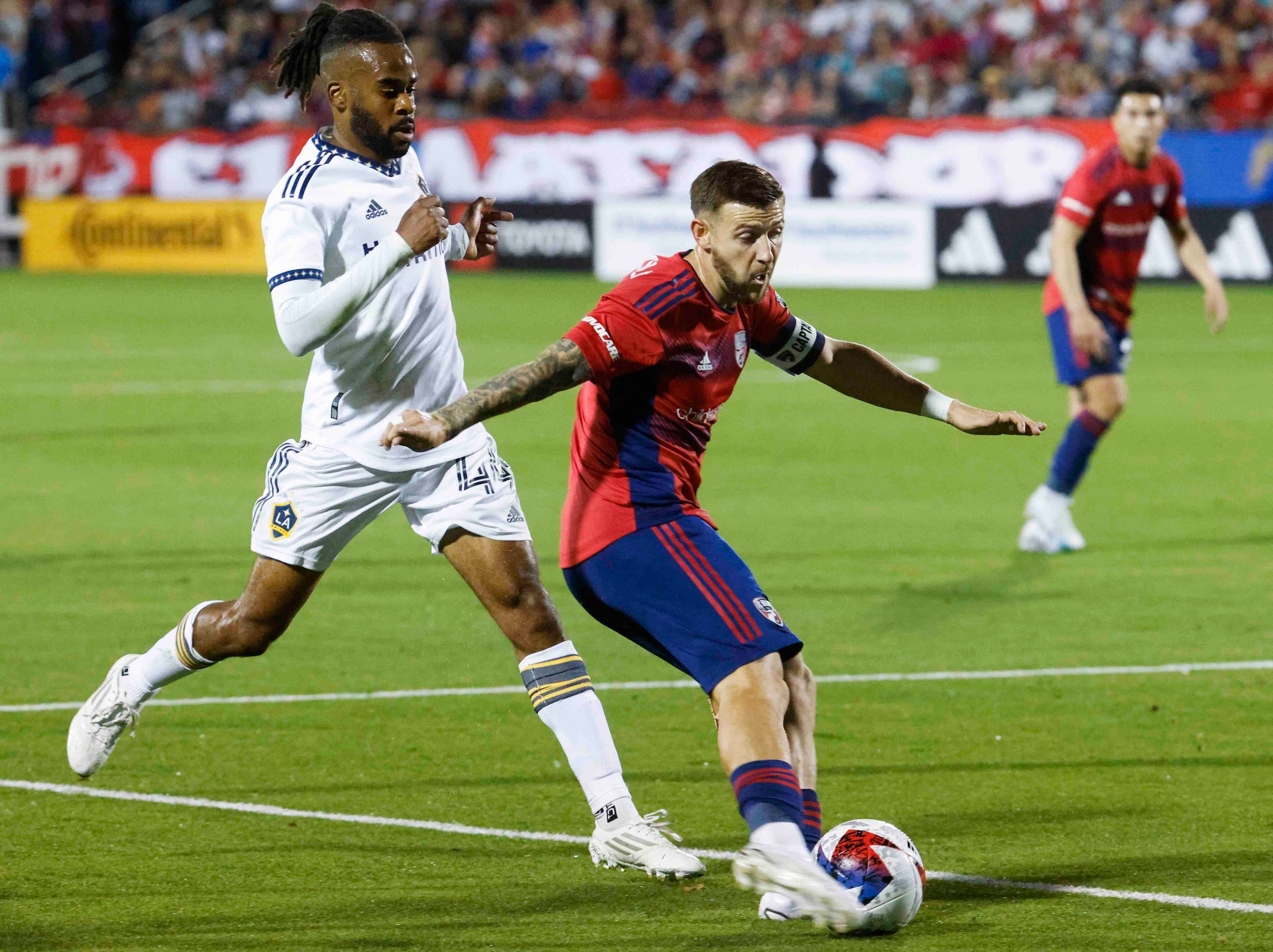 FC Dallas forward Paul Arriola crosses the ball past Los Angeles Galaxy forward Raheem...