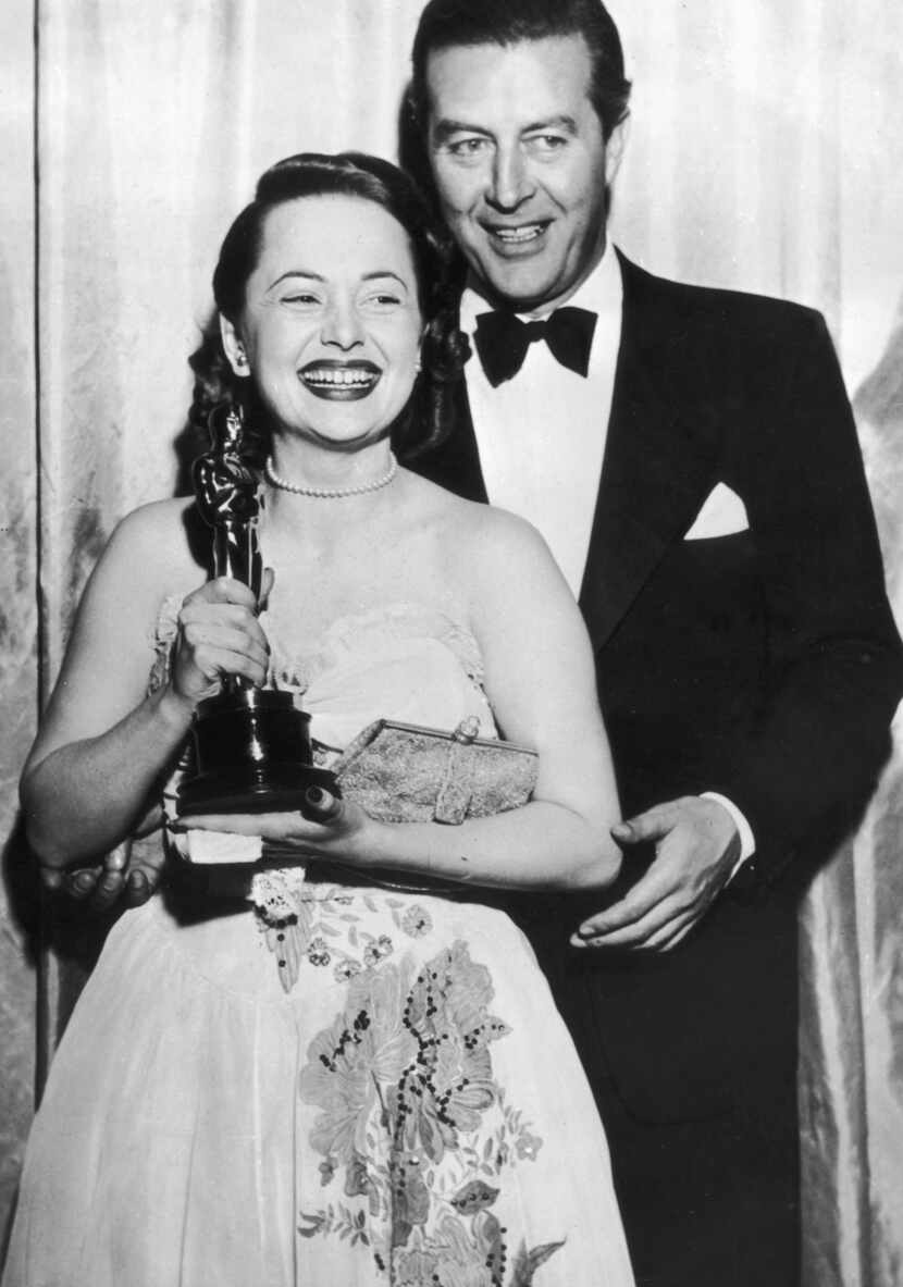 Actress Olivia de Havilland receivers her Oscar from actor Ray Milland for her performance...