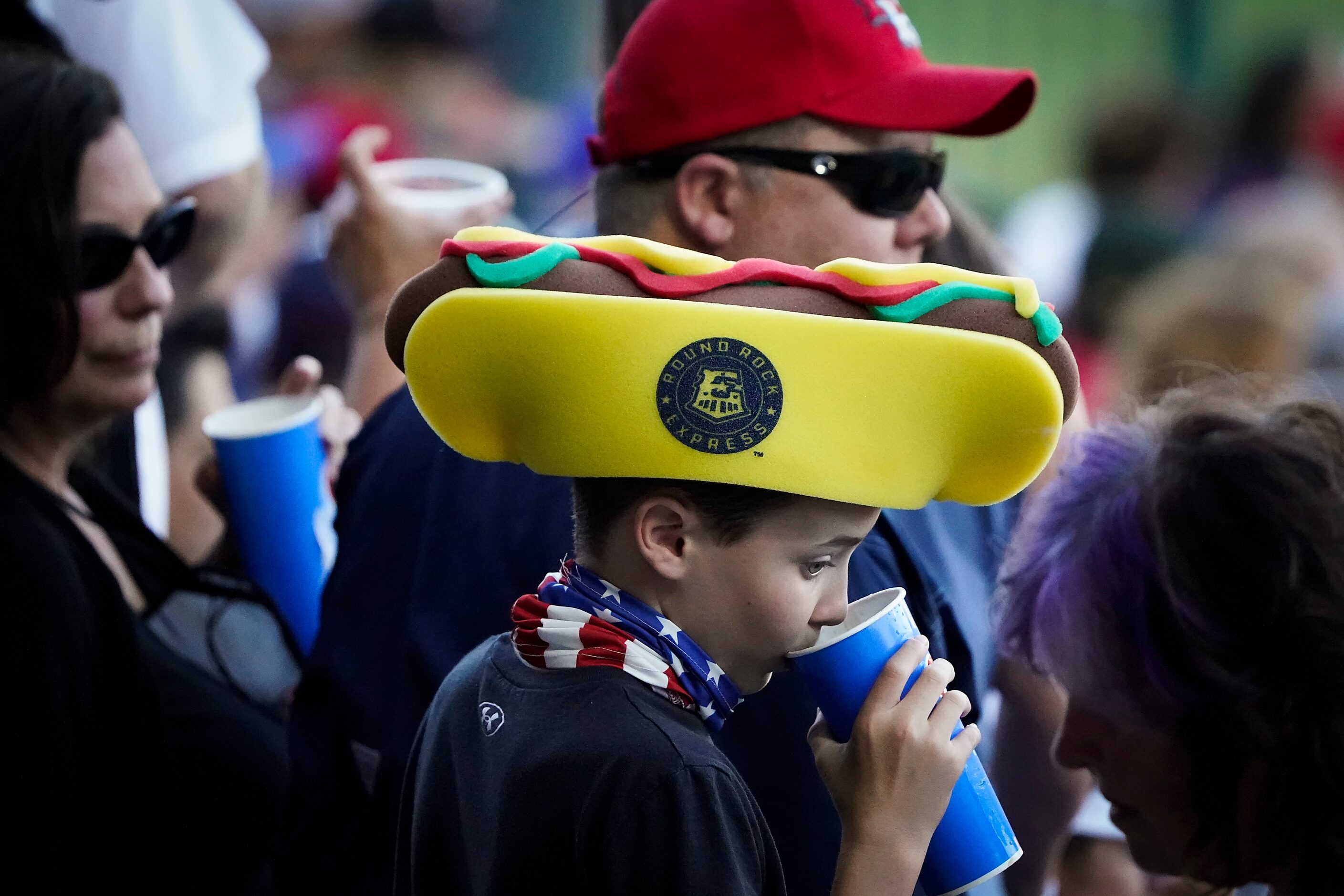 A young fan wears a foam hotdog hat during the first inning of the Round Rock Express season...