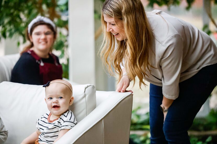 Kendra Gibson plays with baby Birdie Gibson as daughter Morning McKibbin watches.