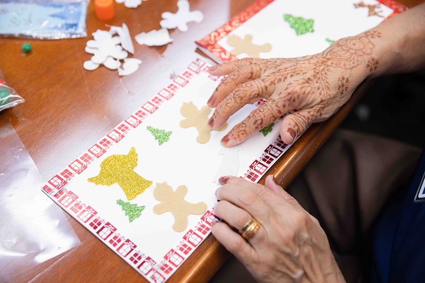 Volunteer Fatima Patel decorates holiday cards as volunteers from The Senior Source’s...