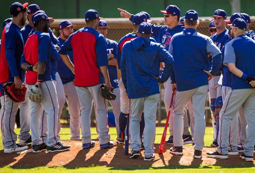 Texas Rangers players gather around bench coach Don Wakamatsu during the first full-squad...
