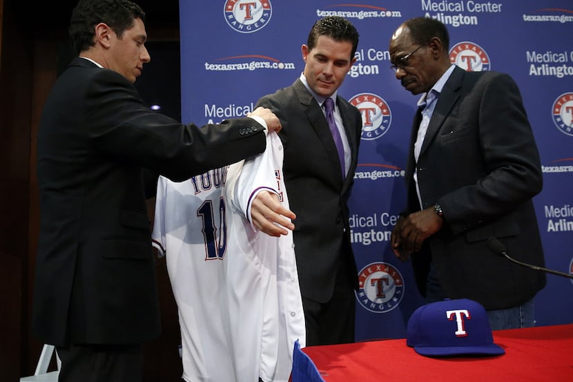 Former Texas Rangers infielder Michael Young receives the new 2014 team jersey, with his...