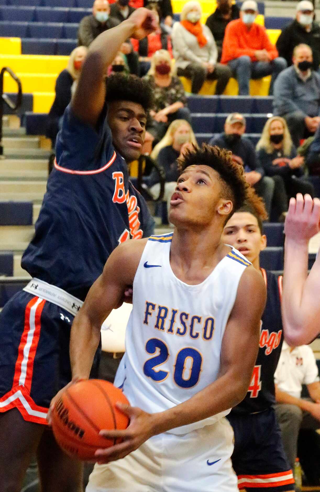 Frisco High School forward Micah Robinson (20) looks to put the ball up under the basket...