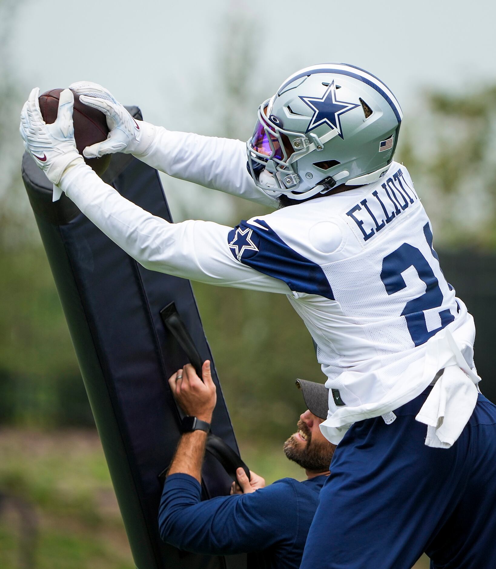 Dallas Cowboys running back Ezekiel Elliott (21) makes a catch while participating in a...