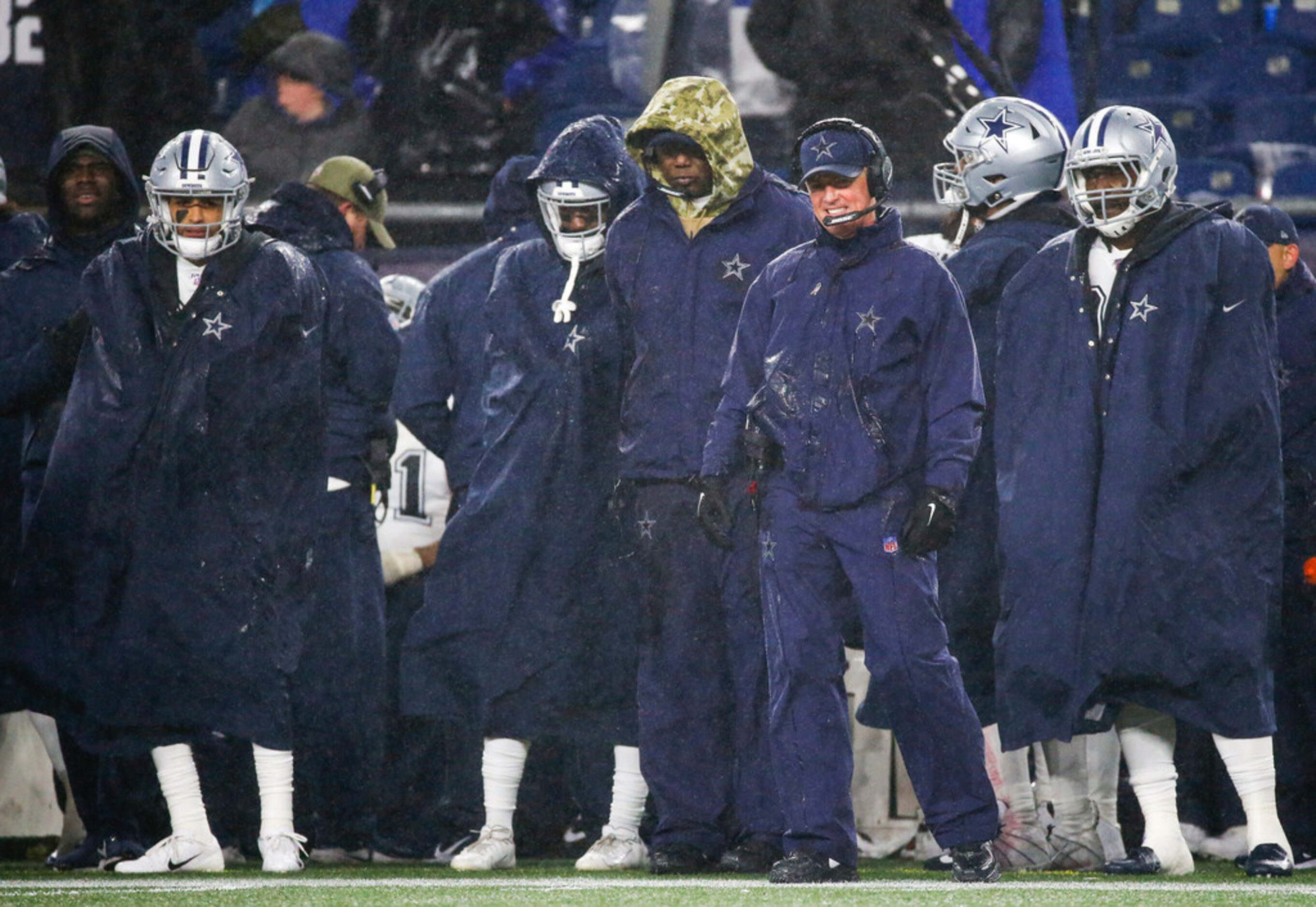 Dallas Cowboys head coach Jason Garrett, third from right, looks to the field during the...