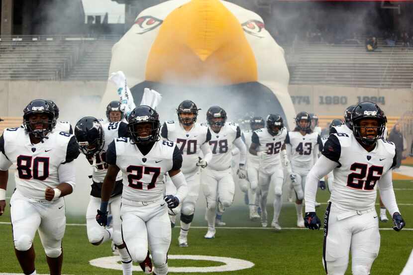 Allen Eagles players bolt onto the field from the team inflatable for the second half of...