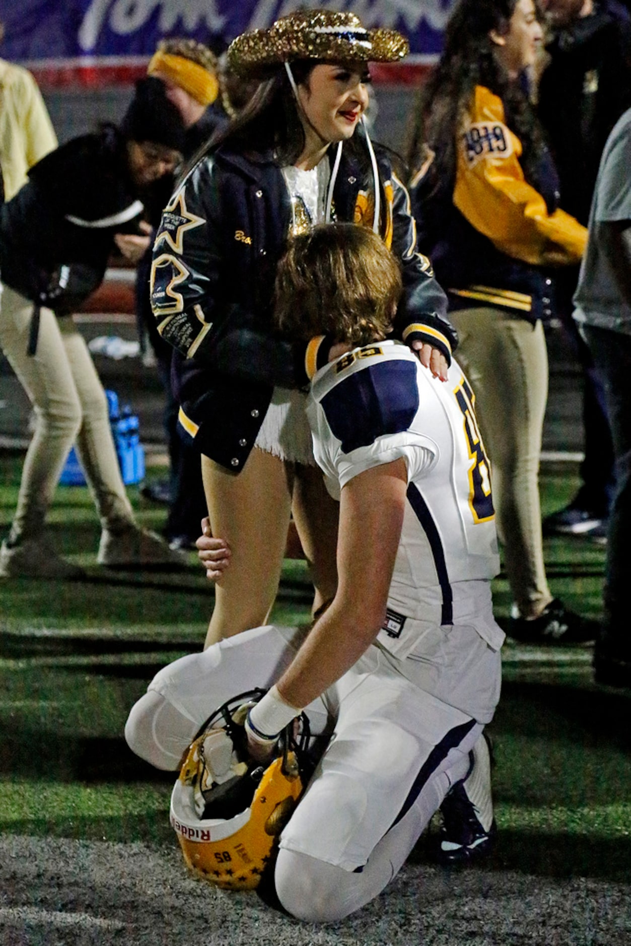 McKinney High Schoolâs Ethan Black (85) is comforted by Brook Naulty of the Marquettes...