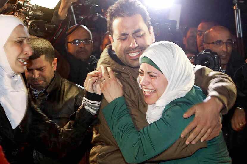 
A man comforts the wife of Jordanian pilot Mu’as al-Kaseasbeh, who is being held by Islamic...