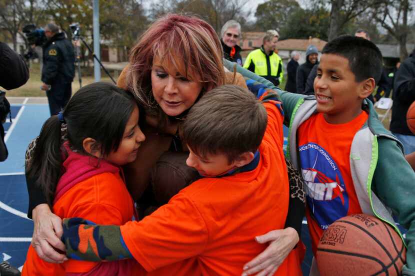 Nancy Lieberman gets hugs from kids during a Dallas Parks and Recreation after-school...