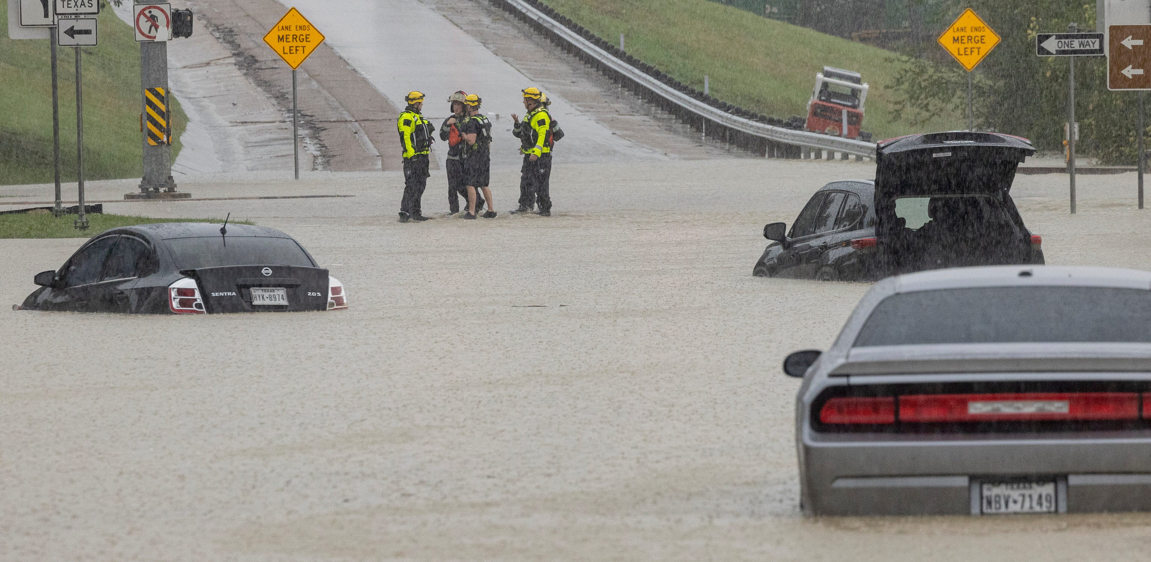 Members of the Mesquite Fire Department survey the stalled cars on the Interstate 635...