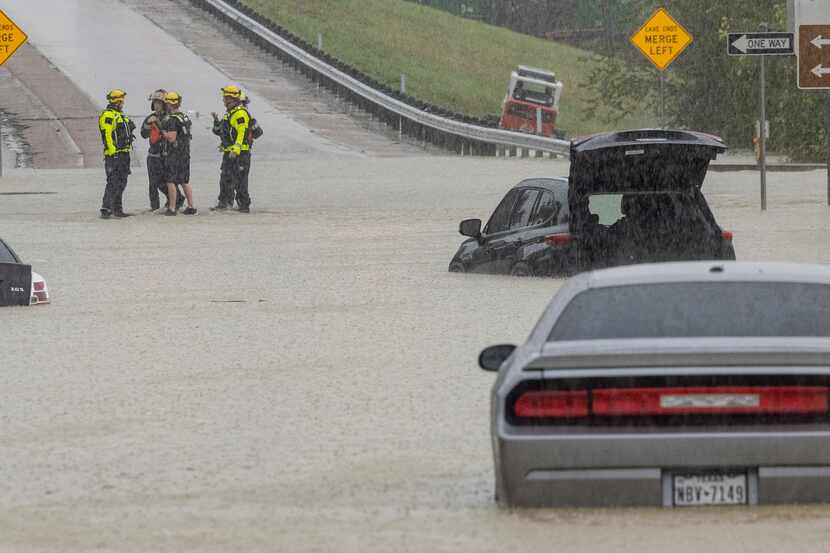 Members of the Mesquite Fire Department survey the stalled cars on the Interstate 635...