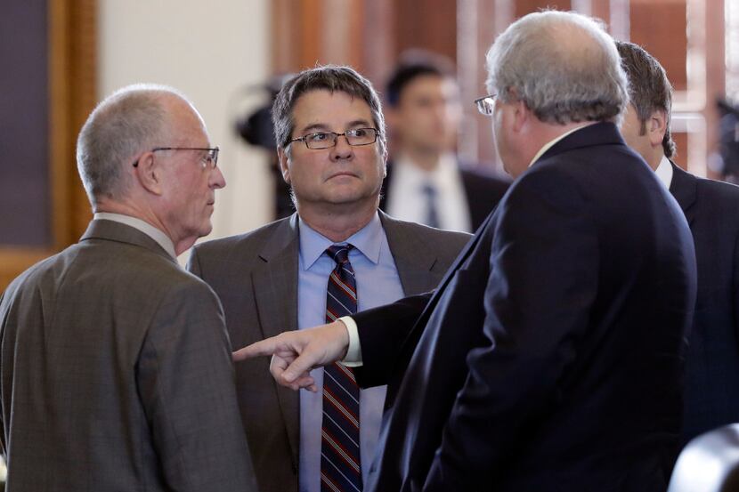 Sen. Charles Perry (center), R-Lubbock, talked with fellow senators before a vote on the...
