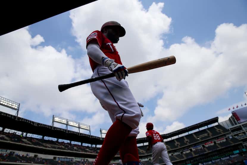 Texas Rangers left fielder Delino DeShields (3) walks back to the dugout after striking out...