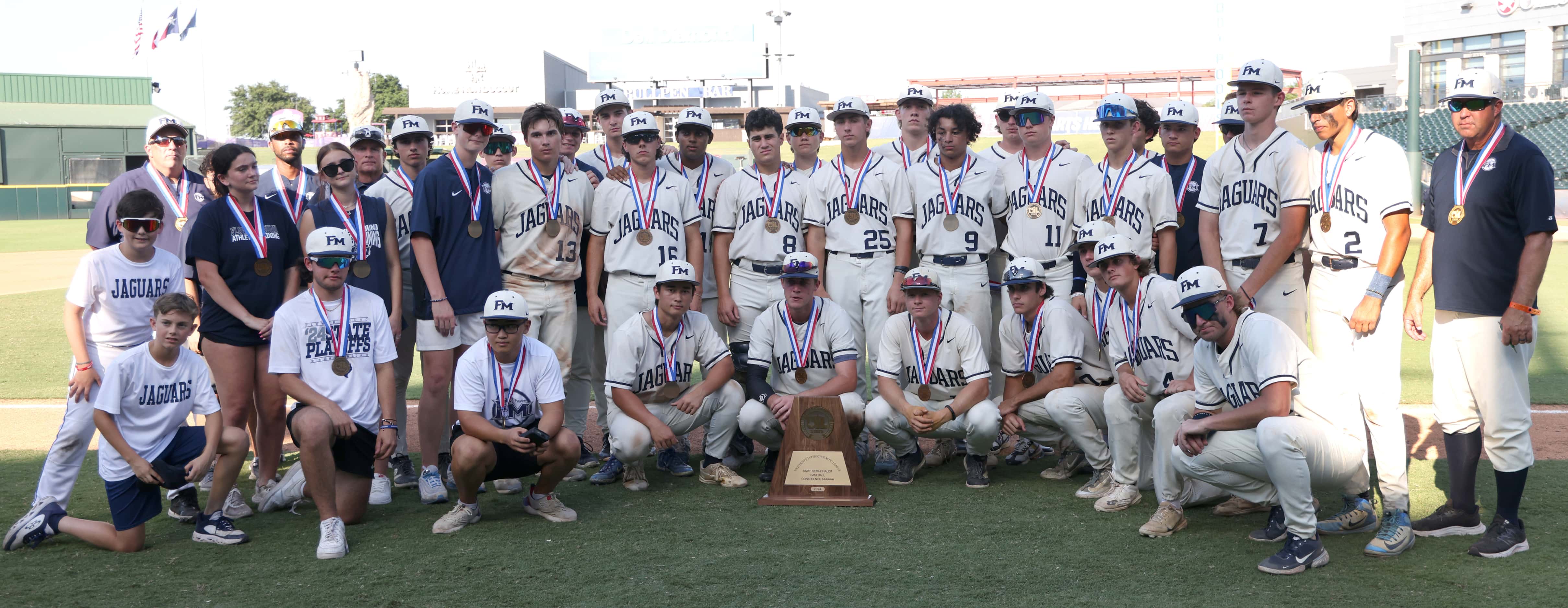 Flower Mound players pose for a team photo with their Class 6A state semi-finalist trophy...