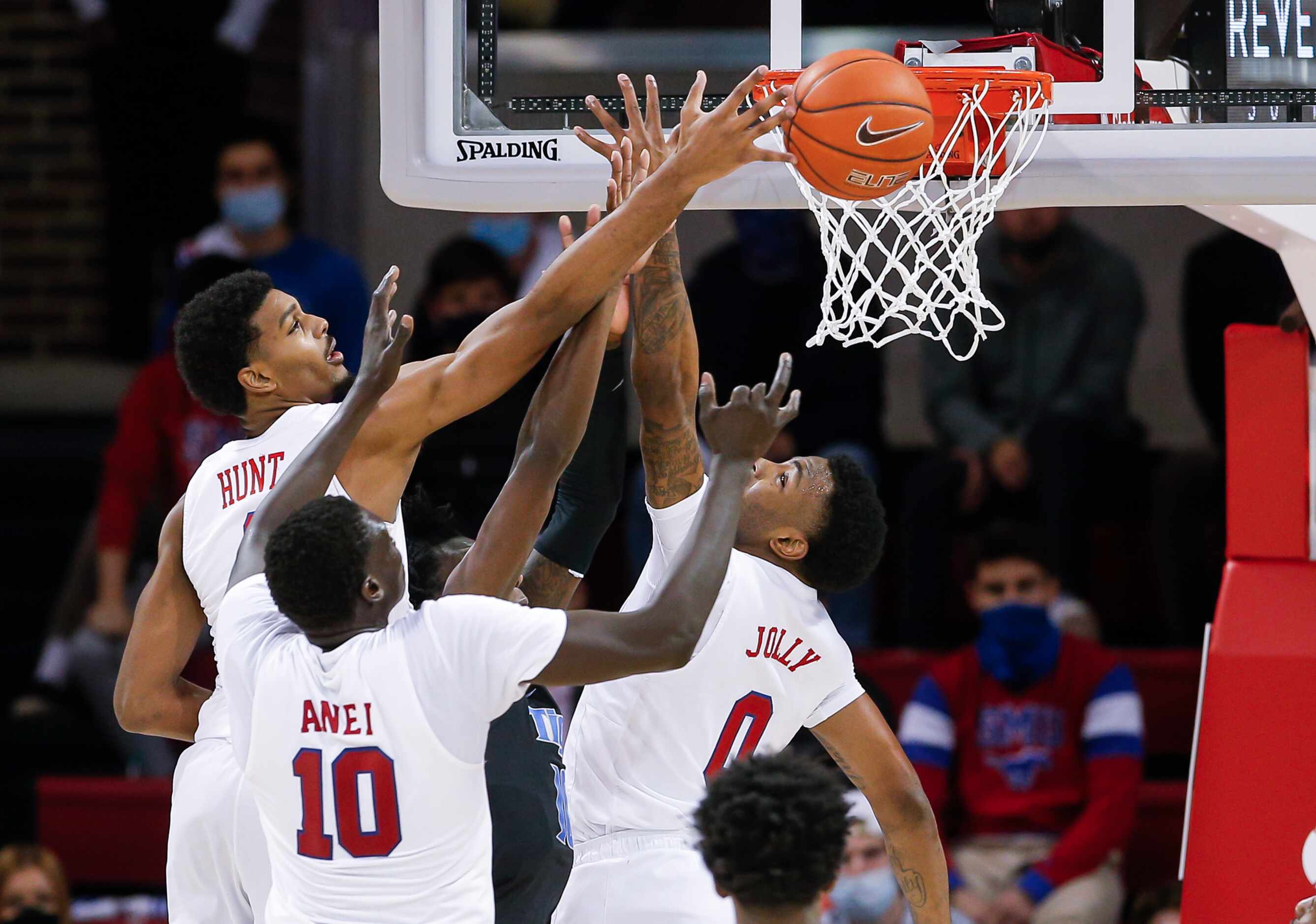 (L to R) SMU forwards Feron Hunt, Yor Anei (10) and guard Tyson Jolly (0) vie for a rebound...