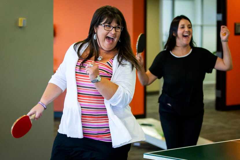  Jeana Long (left) and Renee Greene celebrate making a point in a double table tennis game...