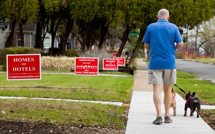 Dale Harwell walks his dogs Nellie and Sophie along Prospect Avenue in Dallas' Edgemont Park...