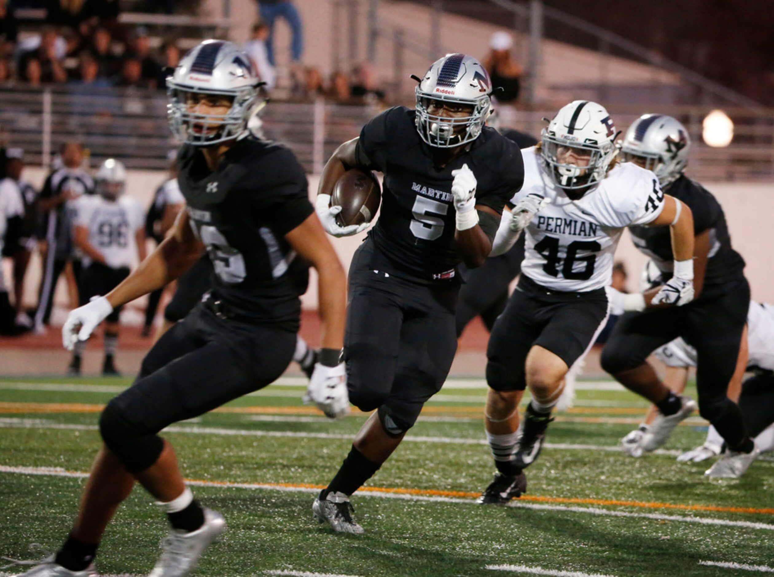 Arlington Martin player Montrell Smith (13) looks to block for teammate Tre Henderson (5) as...